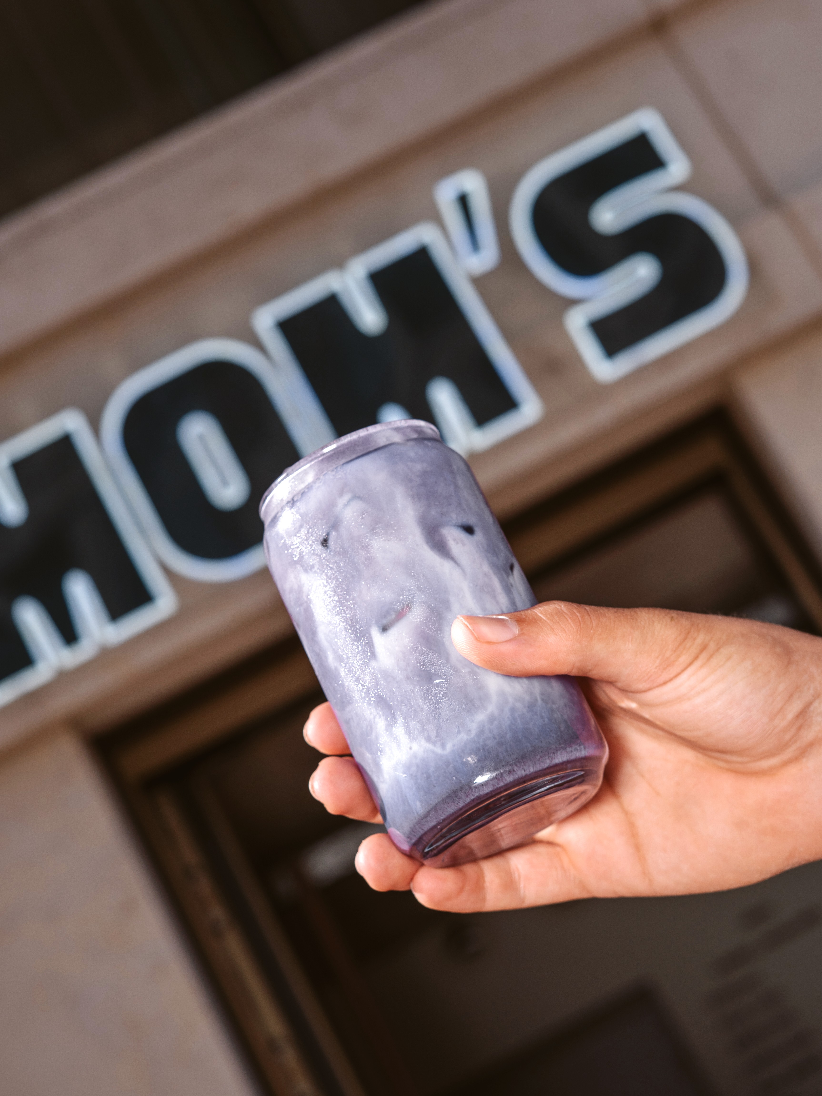 Eisgekühltes Getränk in der Hand vor dem Mom's Schriftzug